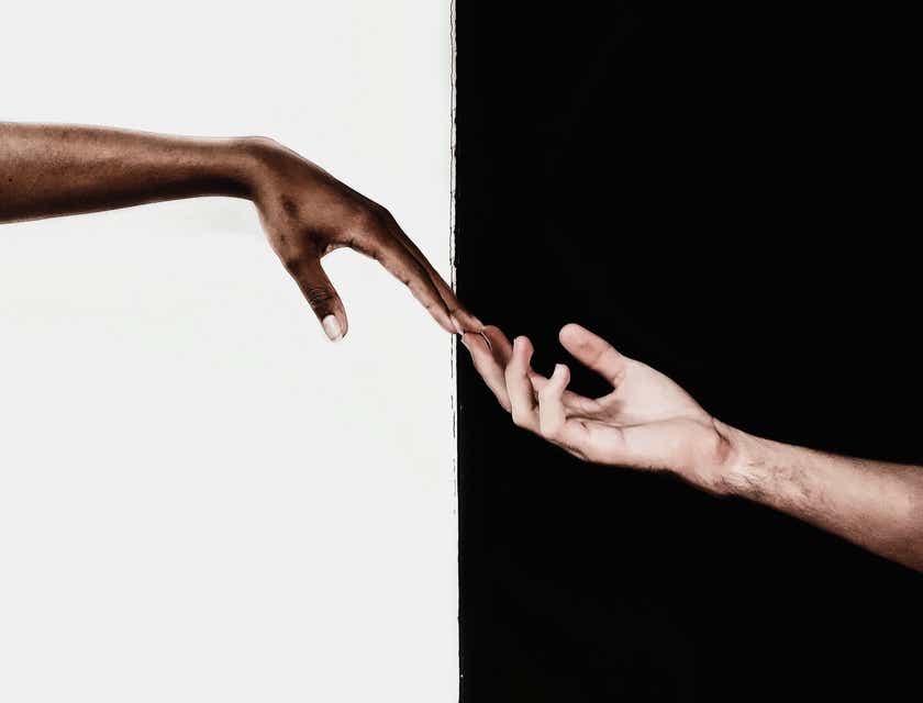 Two hands from different ethnicities reaching out to eachother