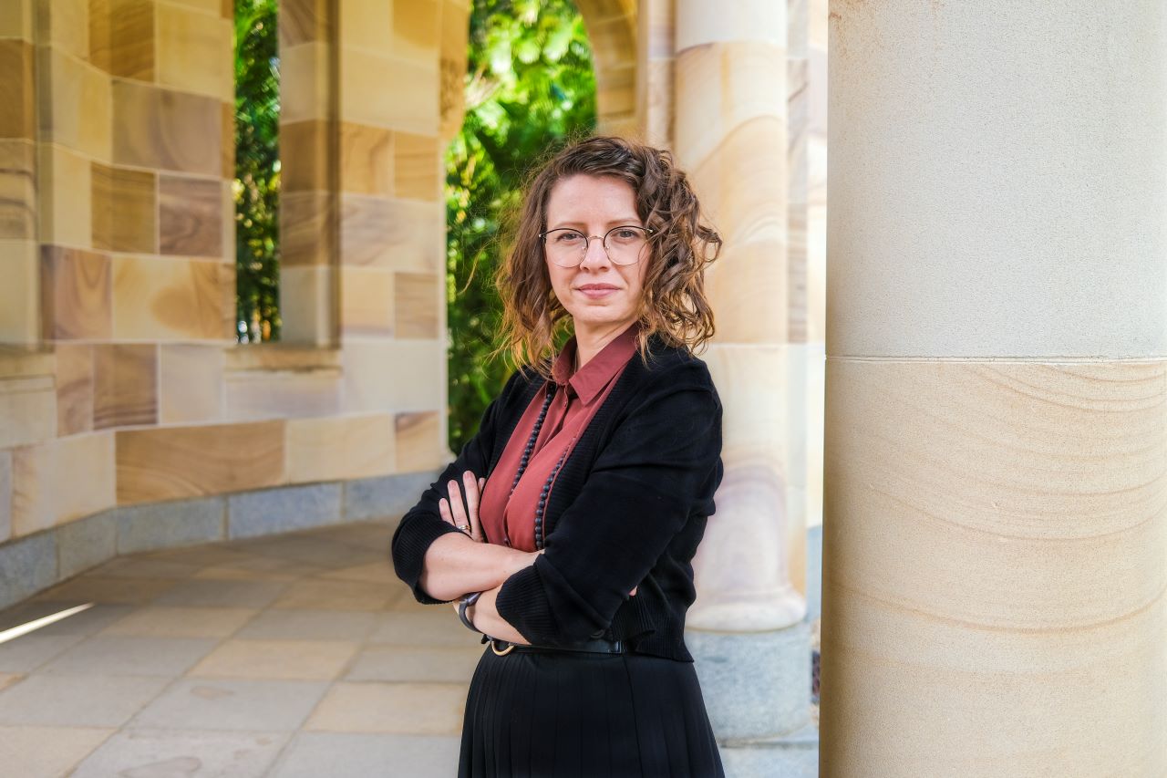 portrait of Rebecca Hausler at the UQ Great Court. She has her arms crossed posed for the picture