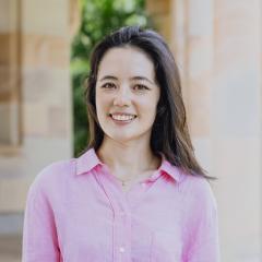 portrait of Dr Annita Stell at the UQ Great Court. She is wearing a pink blouse smiling into the camera.