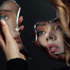a photography of a girl holding a broken mirror