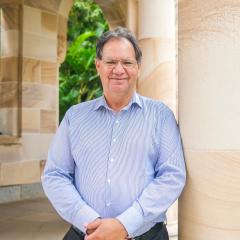 portrait of Des Crump leaning against a pillar of the UQ Great Court